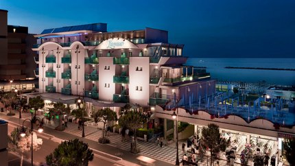 Beleuchtetes Strandhotel Lungomare bei Nacht mit Meerblick