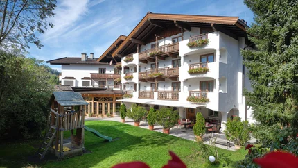 Hotel Metzgerwirt © Andreas Wimmer Hotelgebäude mit Balkonen und Spielplatz im Garten
