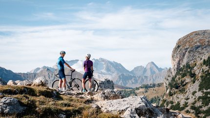 Zwei Radfahrer mit Helm in den Bergen auf einem felsigen Pfad