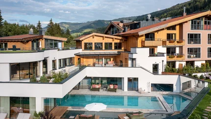 Biohotel Rupertus © Klaus Bauer Modernes Hotel mit Außenpool und Bergblick bei klarem Himmel
